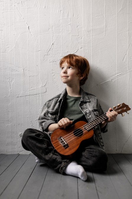 young boy playing Ukulele